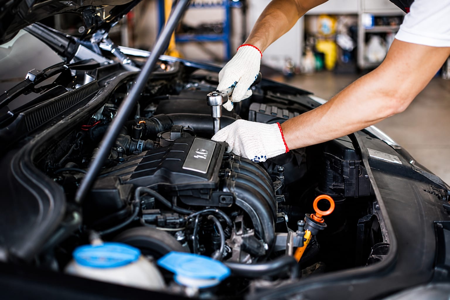 Mecânico da Anhaia Mello Pneus realizando manutenção no motor de um carro